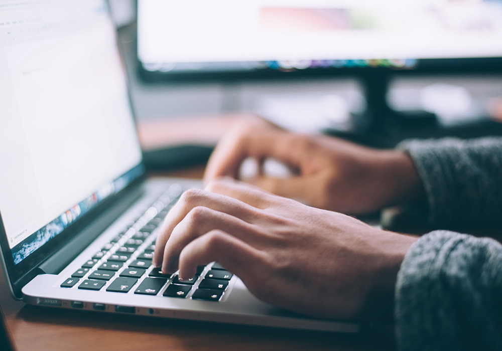 person typing on a laptop